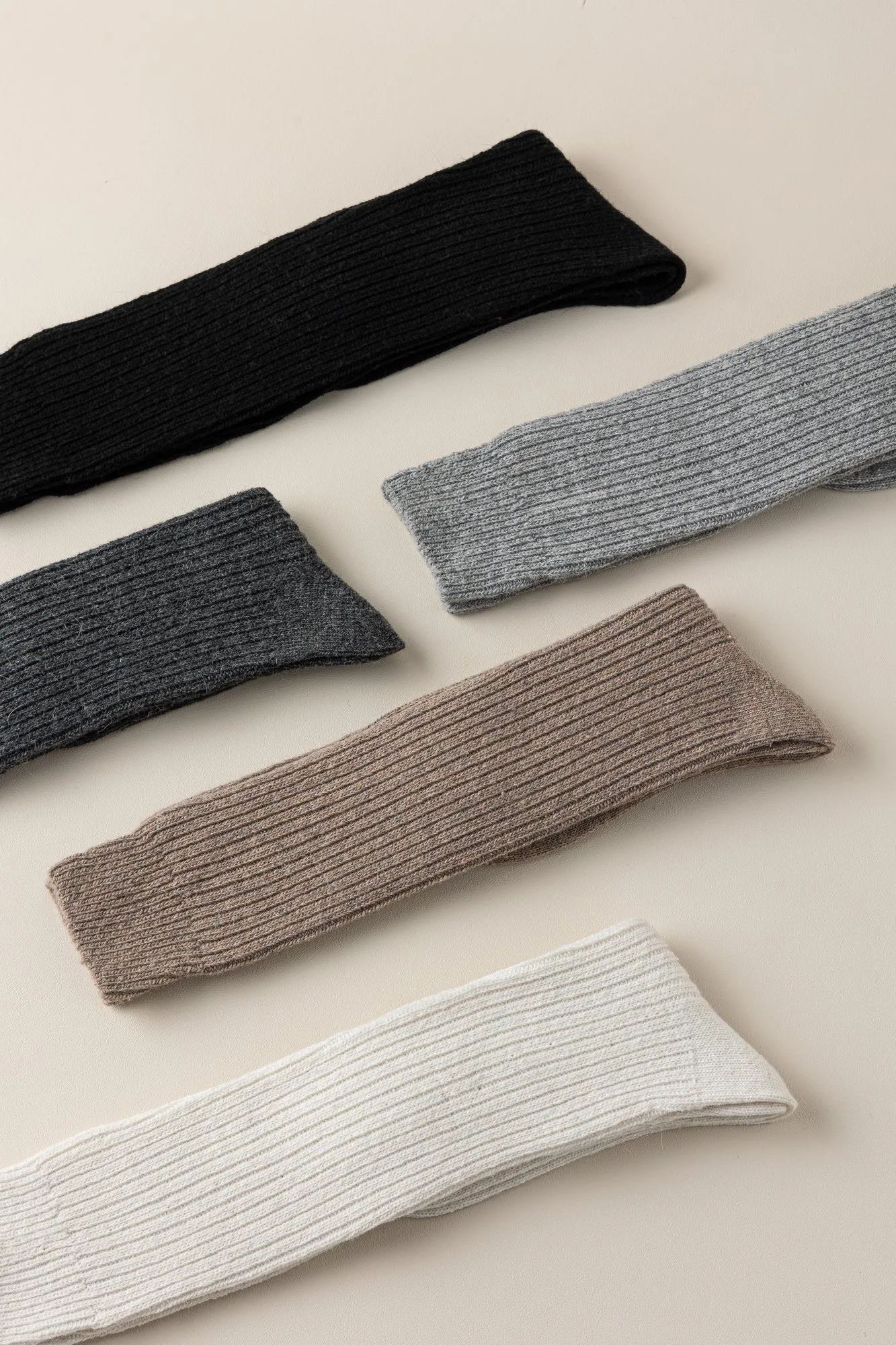 Five wool-blend ribbed knee-high socks laid diagonally, showing the full knee-high length and rib texture.