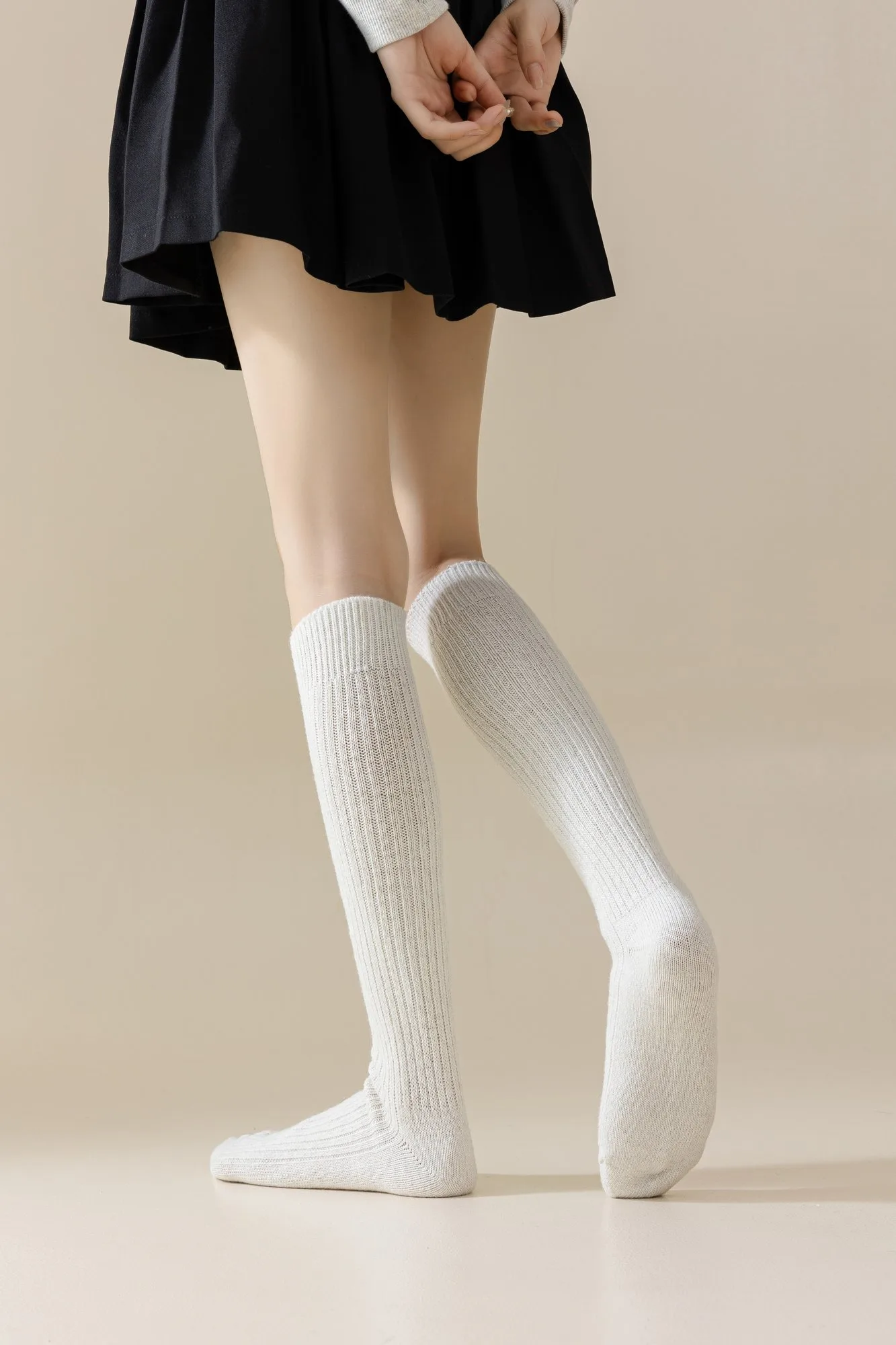 Wool-blend ribbed knee-high socks worn on both legs, photographed from behind to show the fit up the calf.
